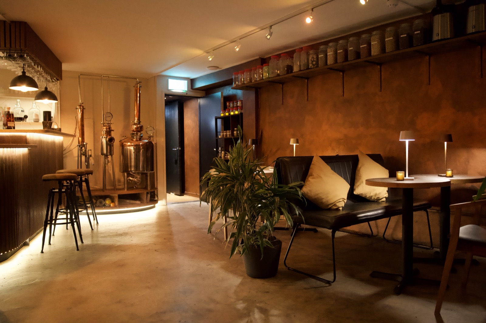 Intimate seating area and spirits shelf at The Distillery