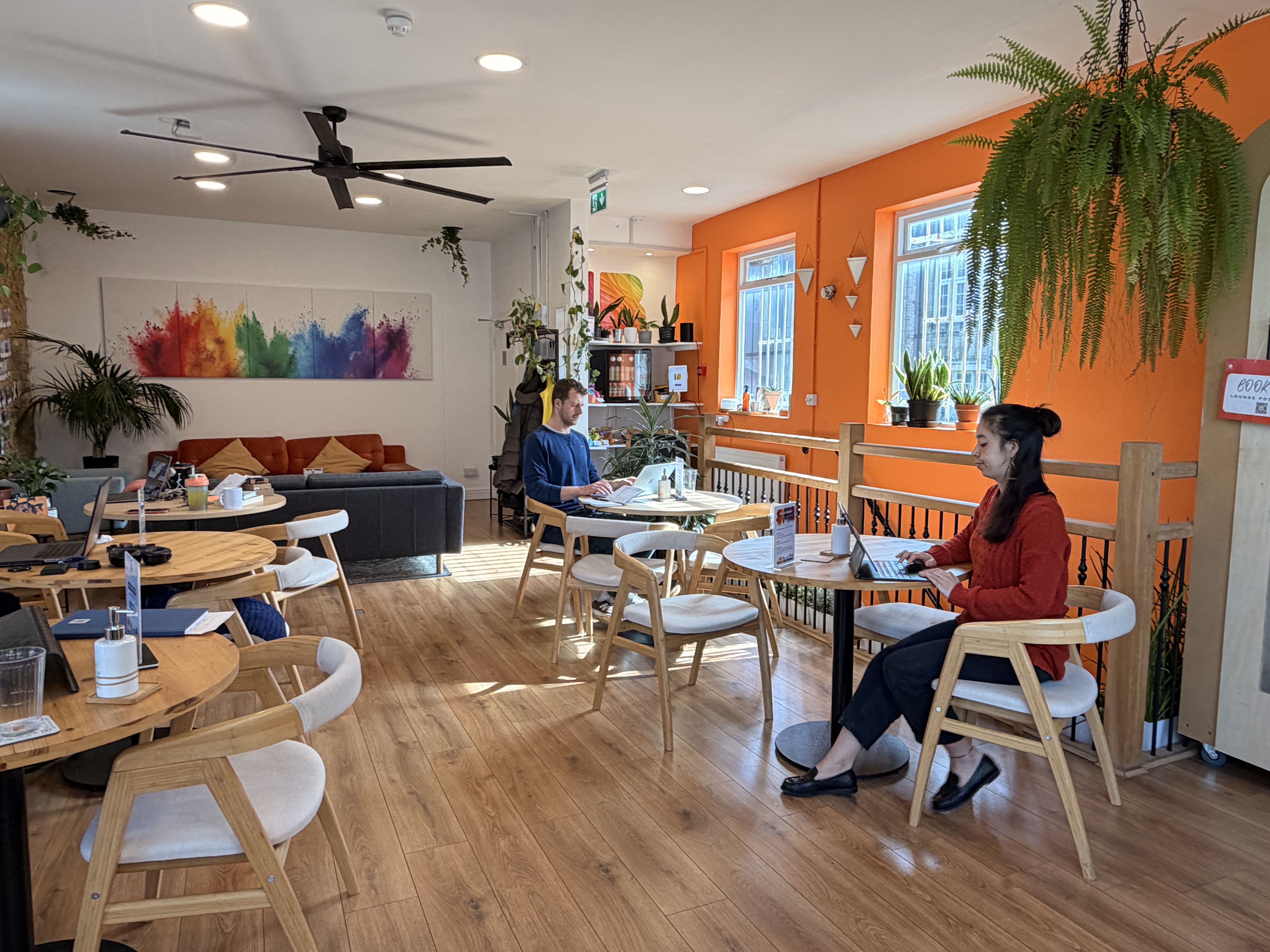 Members working in the sunlit lounge at Impact Brixton
